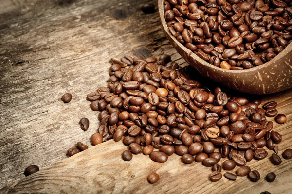 Wooden cup with coffee-beans on wooden table — Stock Photo, Image