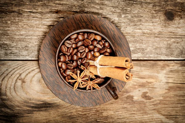 Trä cup med kaffebönor på träbord — Stockfoto