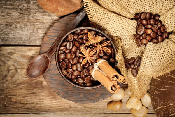 Copo de madeira com grãos de café na mesa de madeira — Fotografia de Stock