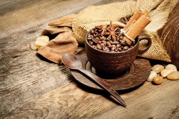 Taza de madera con granos de café en la mesa de madera — Foto de Stock