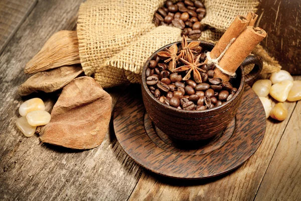 Taza de madera con granos de café en la mesa de madera — Foto de Stock