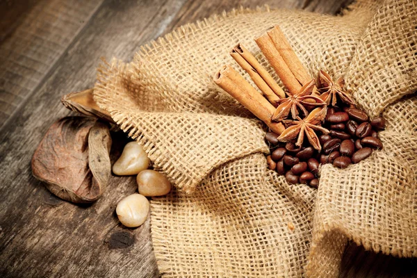 Canela, anis estrelado e grãos de café na mesa de madeira velha — Fotografia de Stock