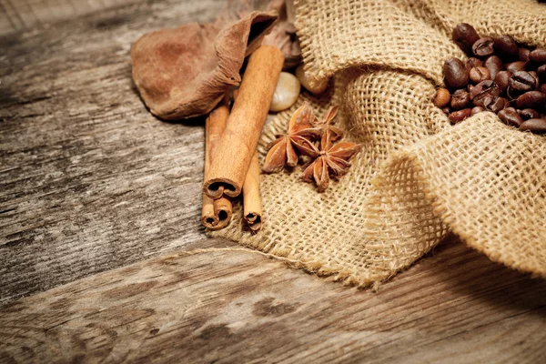 Cannelle, anis étoilé et grains de café sur une vieille table en bois — Photo