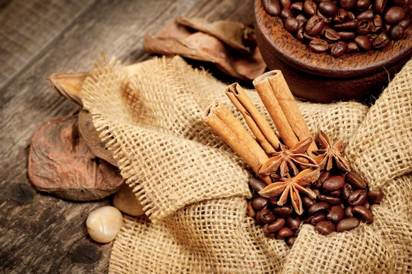 Cinnamon, star anise and coffee beans on old wooden table — Stock Photo, Image