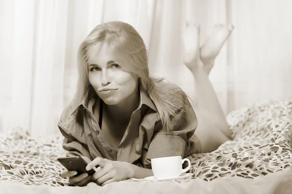 Mujer acostada en la cama y usando el teléfono móvil y ofendiéndose —  Fotos de Stock