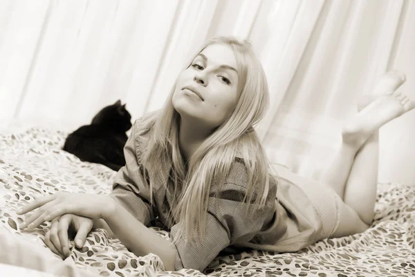 Donna sdraiata sul letto con gatto balck . — Foto Stock