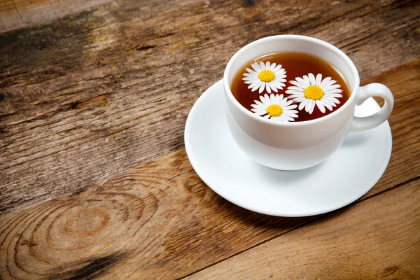 Herbal tea with chamomile on old wooden table — Stock Photo, Image