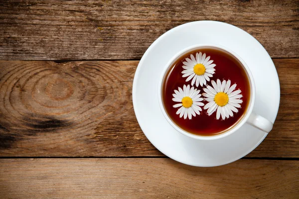 Herbal tea with chamomile on old wooden table — Stock Photo, Image