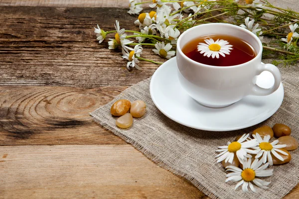 Herbal tea with chamomile on old wooden table — Stock Photo, Image