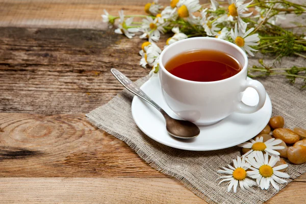 Herbal tea with chamomile on old wooden table — Stock Photo, Image