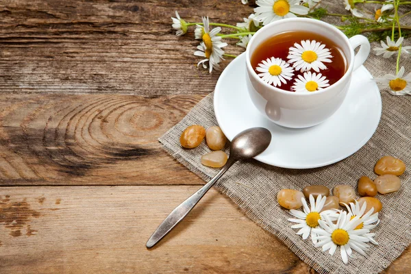 Herbal tea with chamomile on old wooden table — Stock Photo, Image