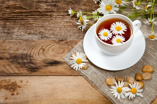 Herbal tea with chamomile on old wooden table — Stock Photo, Image