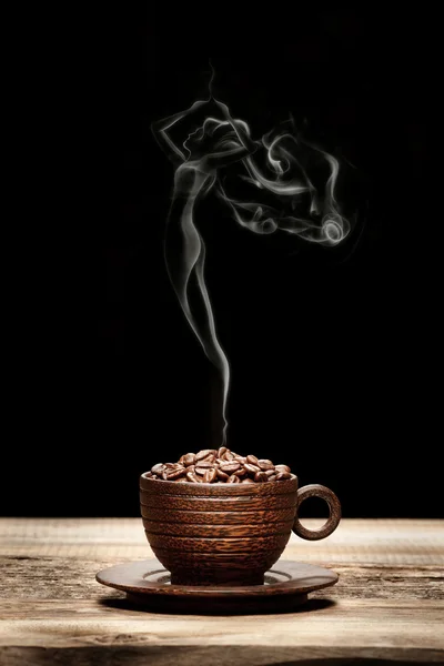 Wooden cup with beans and woman-shaped smoke — Stock Photo, Image