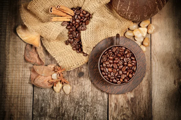 Wooden cup with coffee-beans on wooden table — Stock Photo, Image