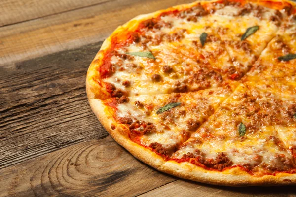 Pizza boloñesa sobre mesa de madera . —  Fotos de Stock