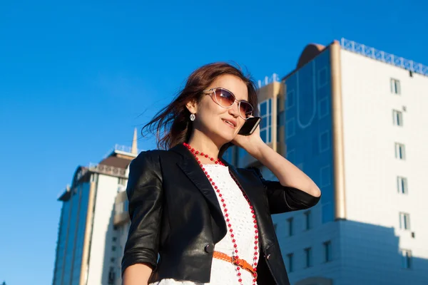 Attraente donna d'affari che utilizza un telefono cellulare in città — Foto Stock