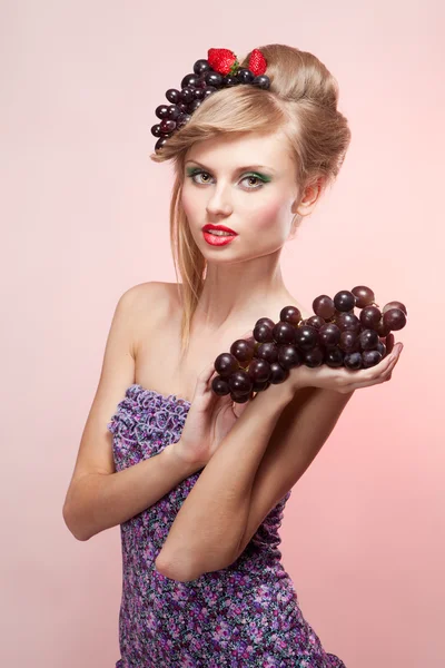 Woman with strawberry and bunch of grapes — Stock Photo, Image