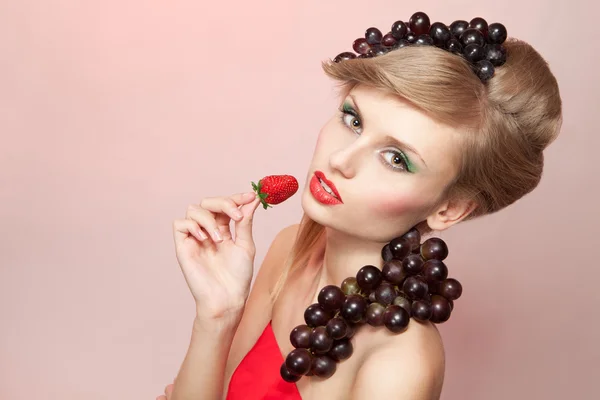 Mujer con fresa y racimo de uvas — Foto de Stock