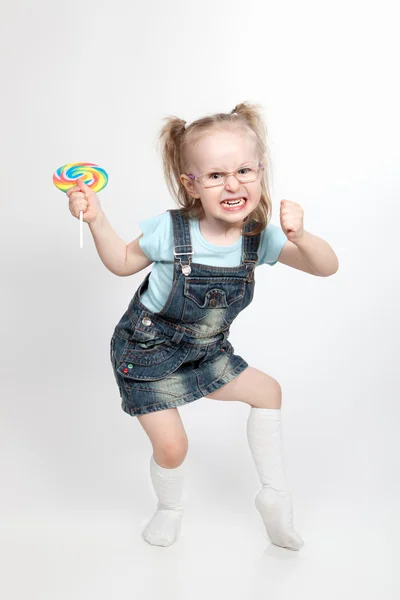 Nyckfulla liten flicka med lollipop — Stockfoto