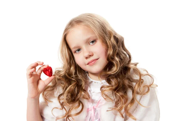 Härlig liten flicka visar choklad godis — Stockfoto