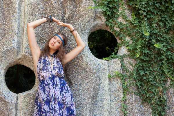 Vrouw in een sundress op de stenen muur — Stockfoto