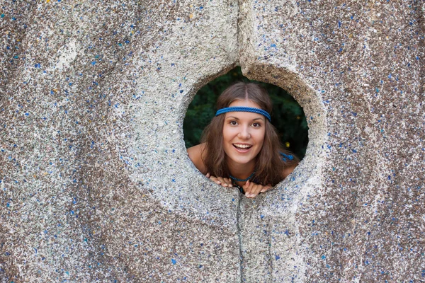 Mujer en un vestido de sol en la pared de piedra — Foto de Stock