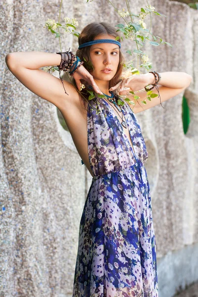 Femme en robe de soleil au mur de pierre — Photo