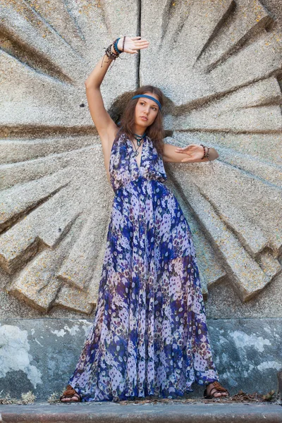 Femme en robe de soleil au mur de pierre — Photo