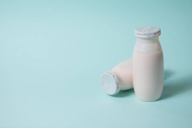Probiyotik ve prebiyotik süt ürünleri içeren şişeler açık mavi arka planda..