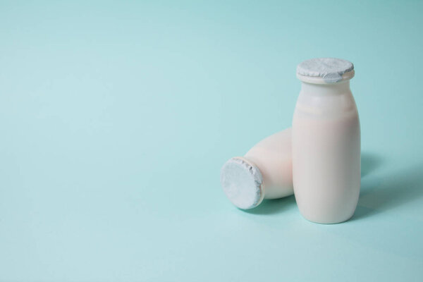 Бутылки с пробиотиками и пребиотиками молочный напиток на светло-голубом фоне.