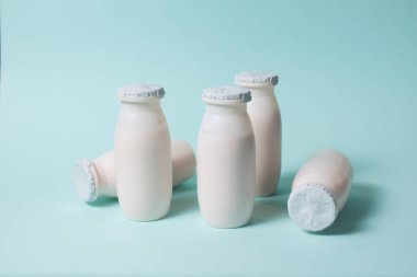 Probiyotik ve prebiyotik süt ürünleri içeren şişeler açık mavi arka planda..