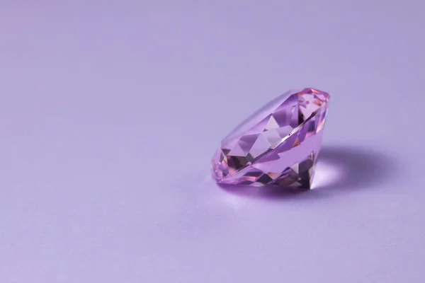 Pedra preciosa roxa para jóias de design. Diamante cristal sobre fundo turquesa. — Fotografia de Stock