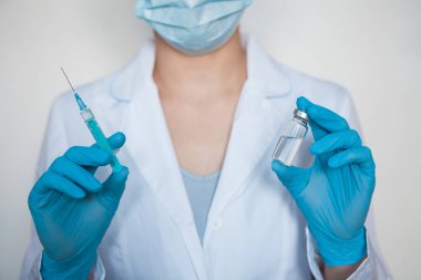 Doktor, hemşire, bilim adamı elinde grip, kızamık, koronavirüs, covid-19 aşısı olan mavi eldivenleri teslim etti..