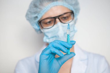 Doktor, hemşire, bilim adamı elinde grip, kızamık, koronavirüs, covid-19 aşısı olan mavi eldivenleri teslim etti..