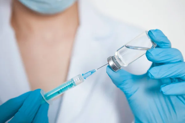 Médecin, infirmière, scientifique main dans les gants bleus tenant la grippe, la rougeole, le coronavirus, le vaccin covid-19. — Photo