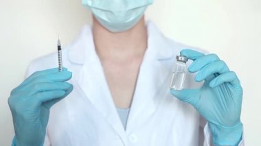 Doktor, hemşire, bilim adamı elinde grip, kızamık, koronavirüs, covid-19 aşısı olan mavi eldivenleri teslim etti..