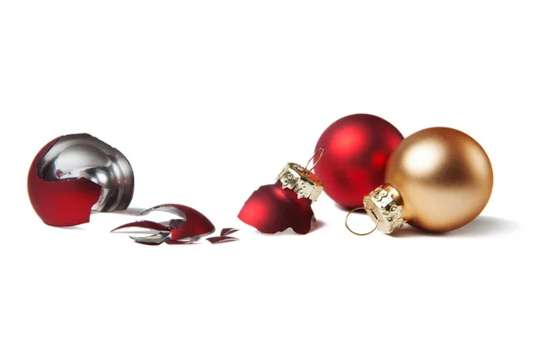 破碎的红色圣诞球和安全的金色圣诞球在孤立的白色背景 选择玻璃球还是塑料球的概念 — 图库照片