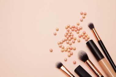 Pembe arka planda çeşitli kozmetik fırçalar. Profesyonel makyaj önleyici pudra göz farı fırçaları. Cilt bakımı için makyaj fırçaları ayarlandı.