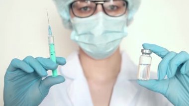 Doktor, hemşire, bilim adamı elinde grip, kızamık, koronavirüs, covid-19 aşısı olan mavi eldivenleri teslim etti..