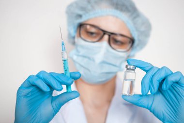 Doktor, hemşire, bilim adamı elinde grip, kızamık, koronavirüs, covid-19 aşısı olan mavi eldivenleri teslim etti..