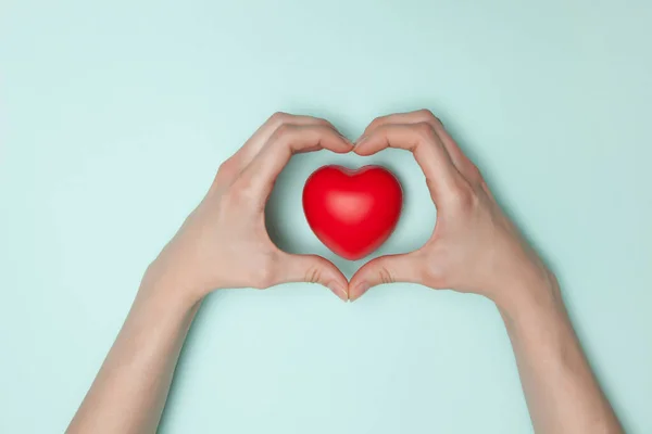 Concept de santé, de médecine et de charité - gros plan des mains féminines avec petit cœur rouge — Photo