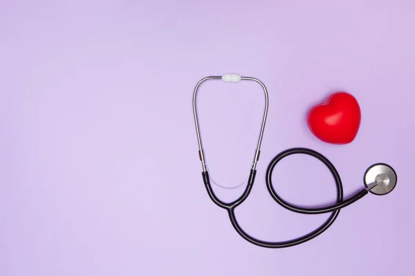 听诊器 红色的心脏和紫色背景的文字空间 健康保险概念 — 图库照片