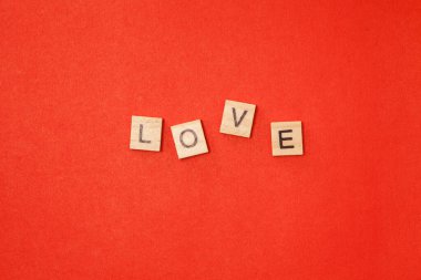 Ahşap bloklar. Kırmızı arka planda aşk kelimesi var. Sevgililer Günü konsepti fotoğrafı.