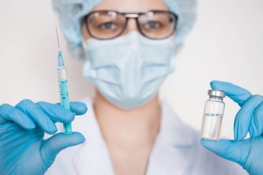 Doktor, hemşire, bilim adamı elinde grip, kızamık, koronavirüs, covid-19 aşısı olan mavi eldivenleri teslim etti..