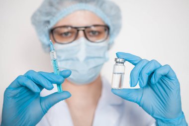 Doktor, hemşire, bilim adamı elinde grip, kızamık, koronavirüs, covid-19 aşısı olan mavi eldivenleri teslim etti..