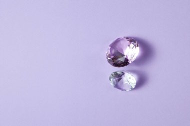 Mücevher tasarımı için mor değerli taşlar. Mor arkaplanda büyük elmas kristali.