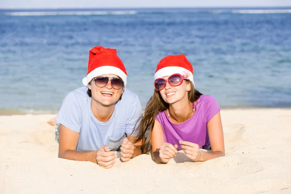 Bella coppia in cappelli di Babbo Natale sulla spiaggia tropicale di Bali — Foto Stock