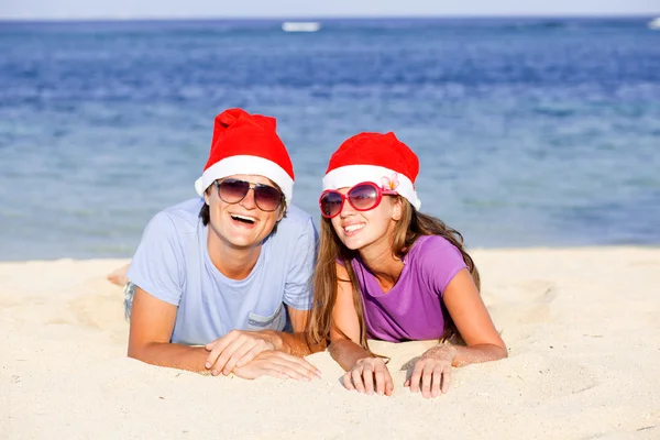 Casal bonito em chapéus de santa na praia tropical de Bali — Fotografia de Stock