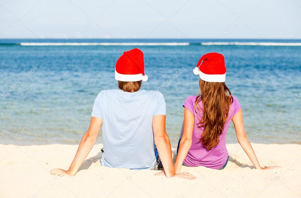 Beautiful coulpe in santa hats on tropical beach of Bali