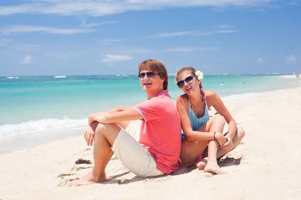 Beau jeune couple assis et s'amusant sur la plage — Photo